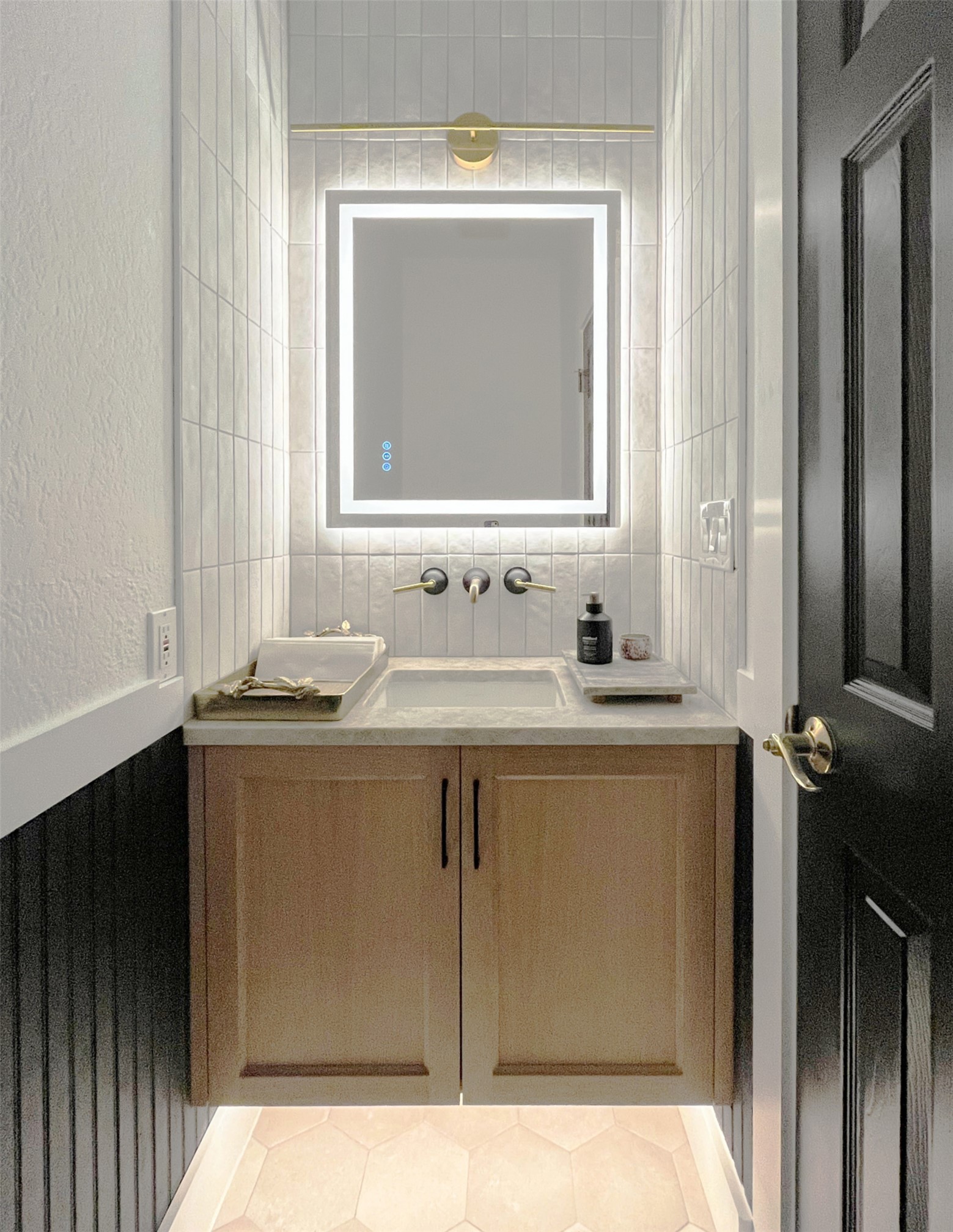 1015 Westland Ridge Road Dripping Springs, TX 78620 - Photo 21 of 32 A well-appointed powder room features a modern vanity with a lighted mirror and sleek fixtures.