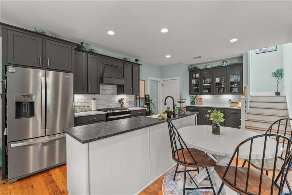1233 Whooping Creek Road Carrollton, GA 30116 - Photo 14 of 61 a kitchen with stainless steel appliances granite countertop a refrigerator a stove a sink a dining table and chairs
