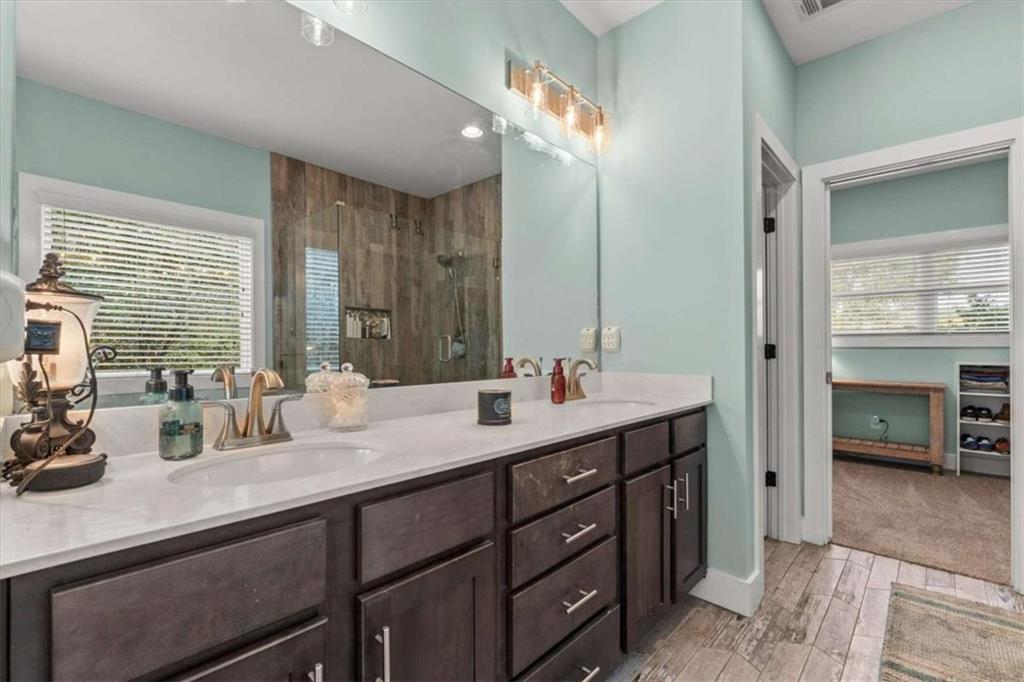 1233 Whooping Creek Road Carrollton, GA 30116 - Photo 28 of 61 a bathroom with double vanity sinks a large mirror and a shower