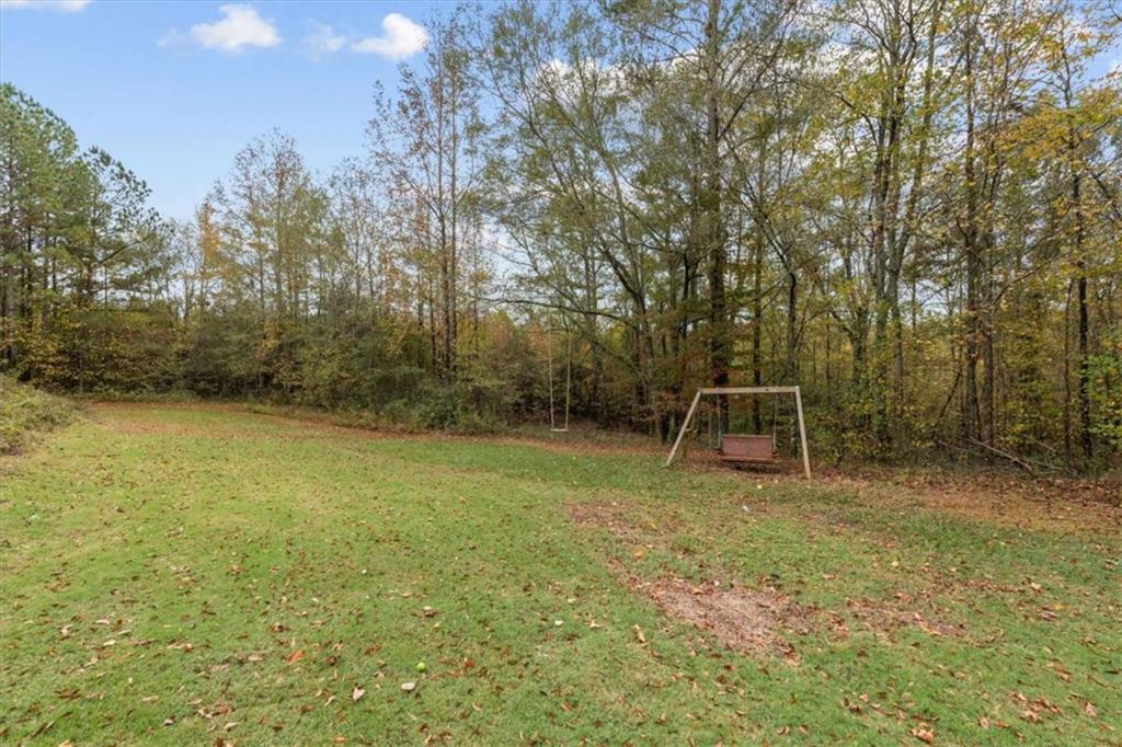 1233 Whooping Creek Road Carrollton, GA 30116 - Photo 57 of 61 a backyard of a house with table and chairs
