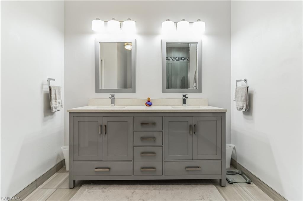 6895 Rain Lily Road, Unit 203 Naples, FL 34109 - Photo 18 of 22 a bathroom with a double vanity sink mirror and