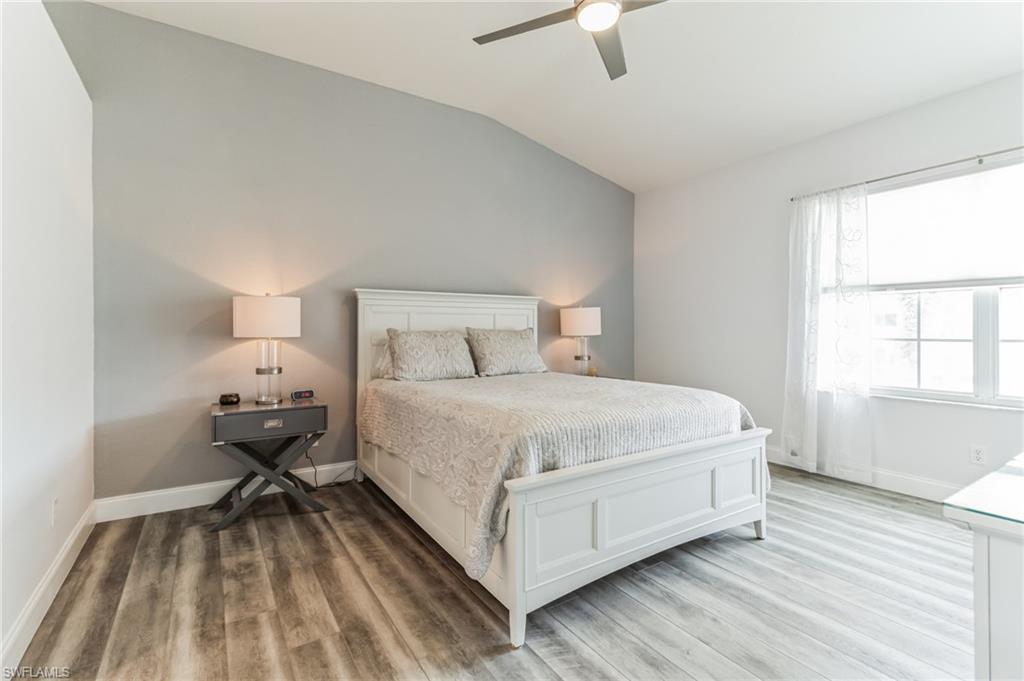 6895 Rain Lily Road, Unit 203 Naples, FL 34109 - Photo 19 of 22 a bedroom with a bed and wooden floor