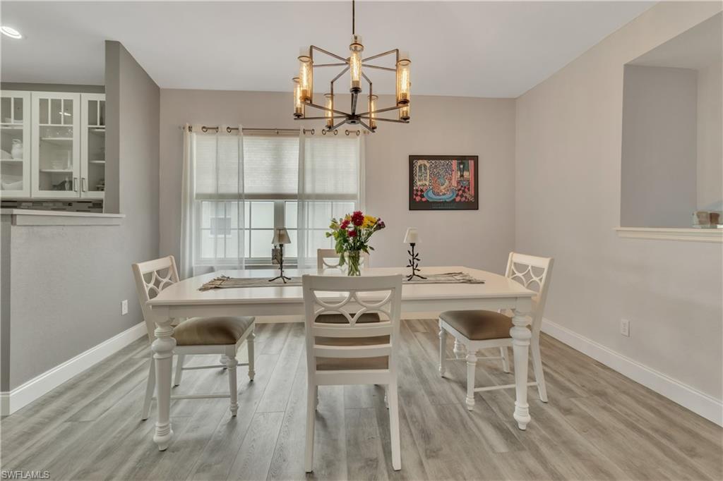 6895 Rain Lily Road, Unit 203 Naples, FL 34109 - Photo 4 of 22 a view of a dining room with furniture window and wooden floor