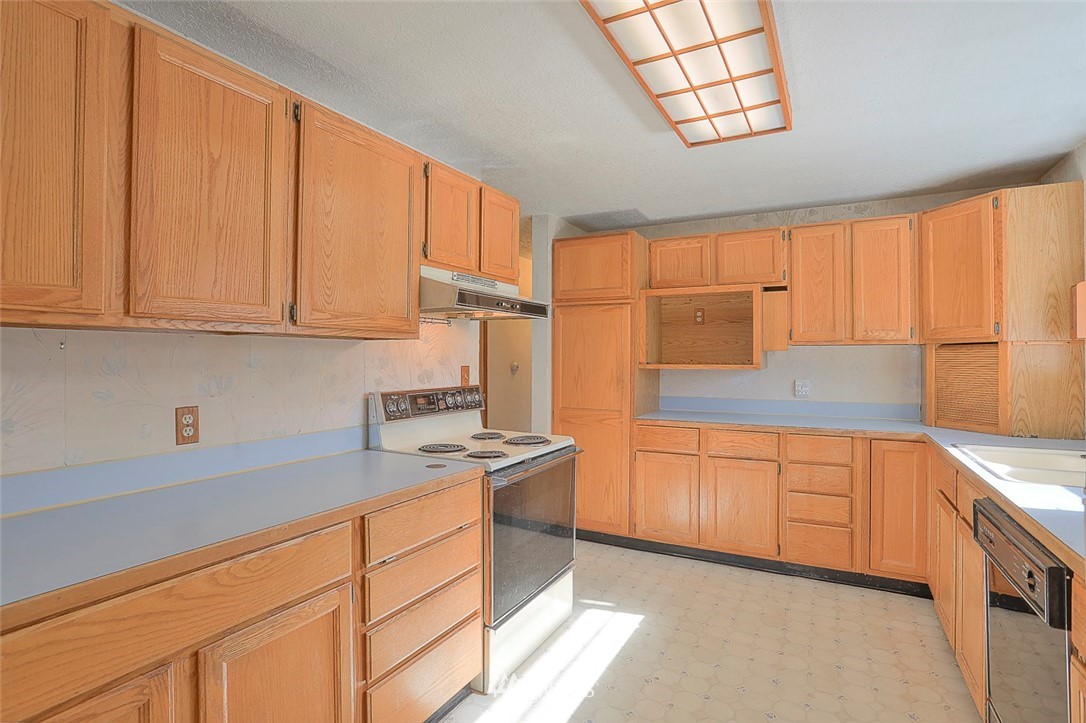 3601 Northeast 10th Street Renton, WA 98056 - Photo 7 of 25 a kitchen with stainless steel appliances granite countertop a sink stove and cabinets