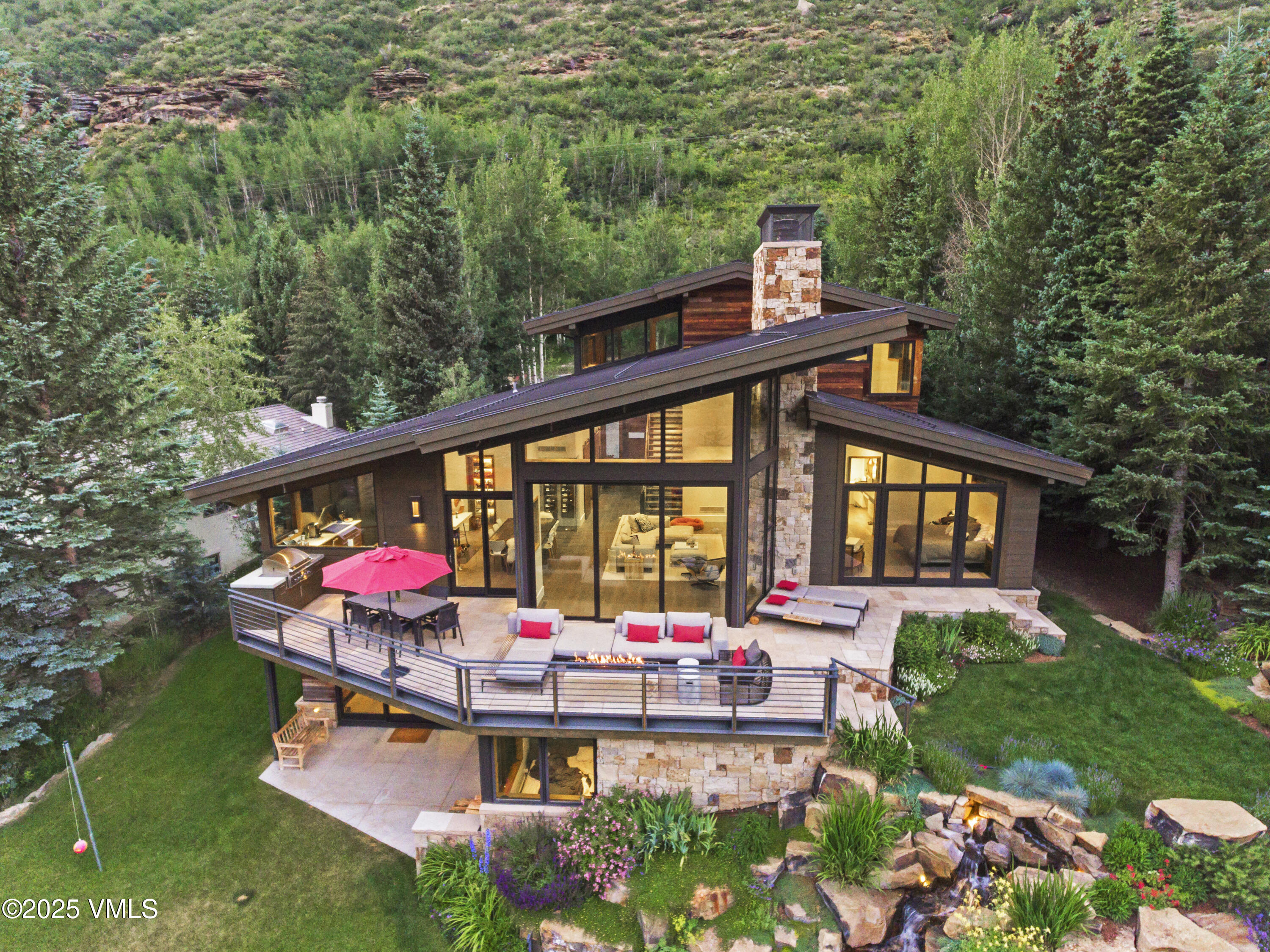 2470 Bald Mountain Road Vail, CO 81657 - Photo 2 of 29 a view of a house with backyard sitting area and garden