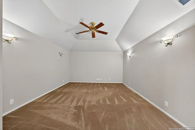 a view of a room with a ceiling fan and window