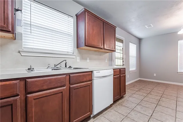 a kitchen with stainless steel appliances granite countertop a sink and a window