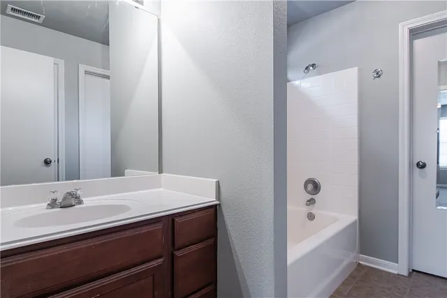 a bathroom with a tub sink and mirror