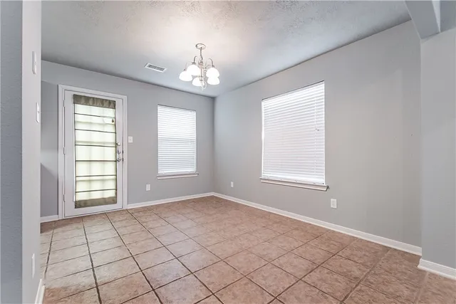 an empty room with windows and chandelier