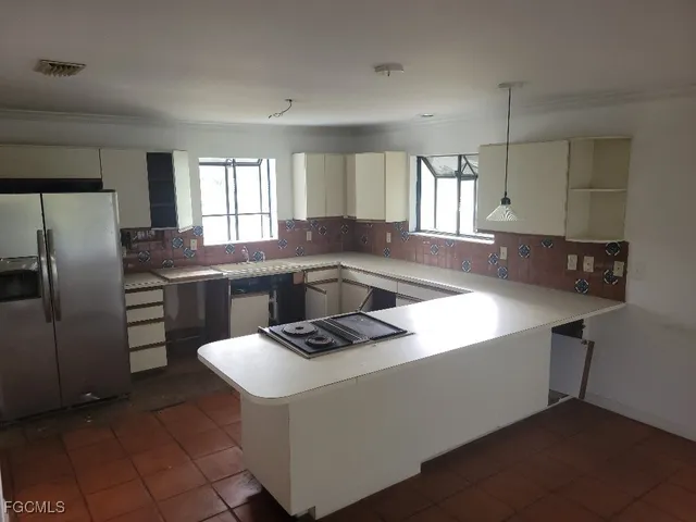 a kitchen with stainless steel appliances granite countertop a sink a stove a refrigerator and island