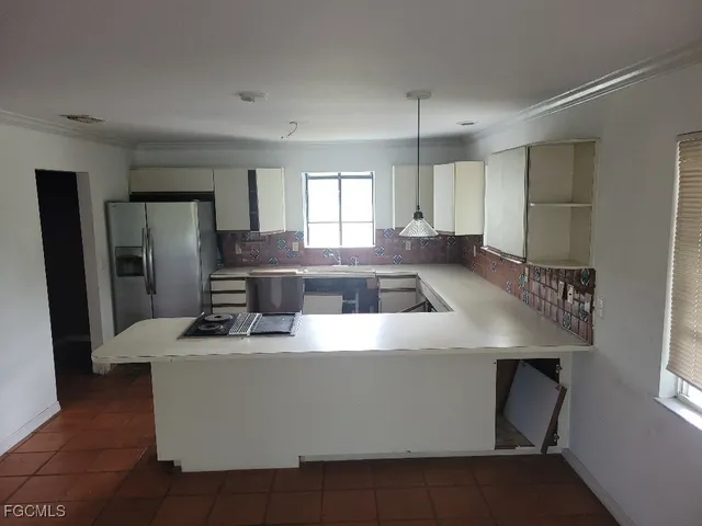 a kitchen with kitchen island stainless steel appliances a sink stove and refrigerator