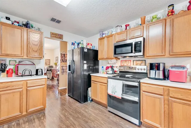 a kitchen with granite countertop a refrigerator stove and sink