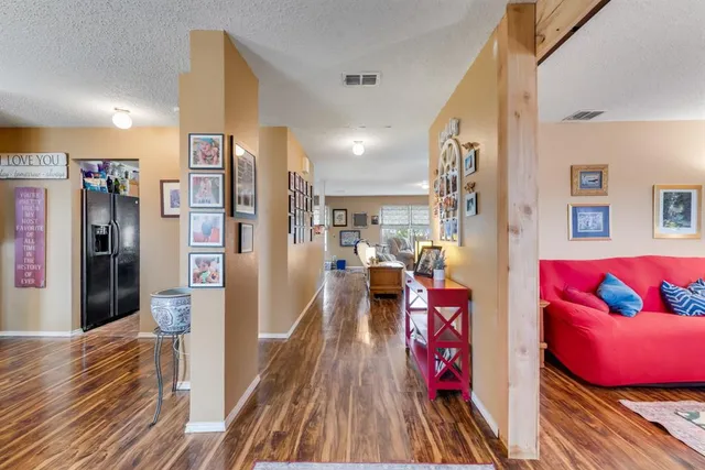 a view of a living room filled with furniture and wooden floor