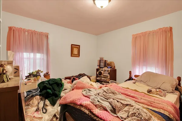 a bedroom with two beds and a potted plant