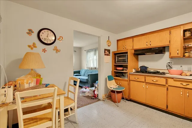 a living room with stainless steel appliances furniture a rug and a window
