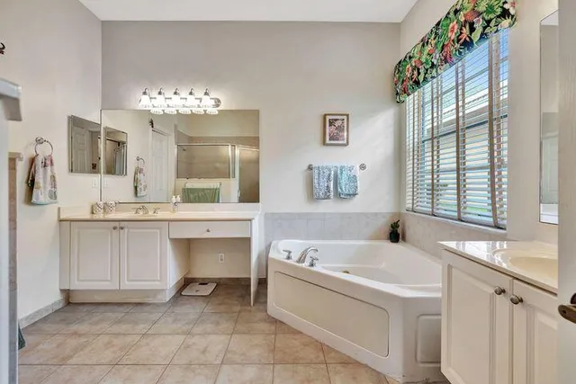 a spacious bathroom with a sink a large mirror and a bathtub