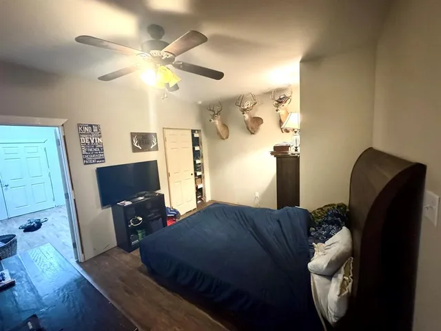 a bedroom with a bed and wooden floor