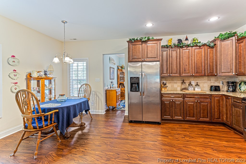 4532 Niagara Carthage Road Carthage, NC 28327 - Photo 13 of 44 a kitchen with stainless steel appliances granite countertop a refrigerator a sink dishwasher a dining table and chairs with wooden floor