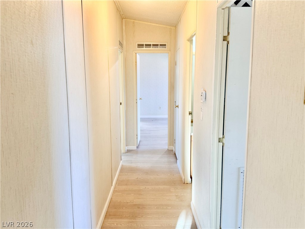 6471 Hafen Ranch Road Pahrump, NV 89061 - Photo 15 of 22 A well-lit passage with durable plank flooring guides you through the home's functional layout.