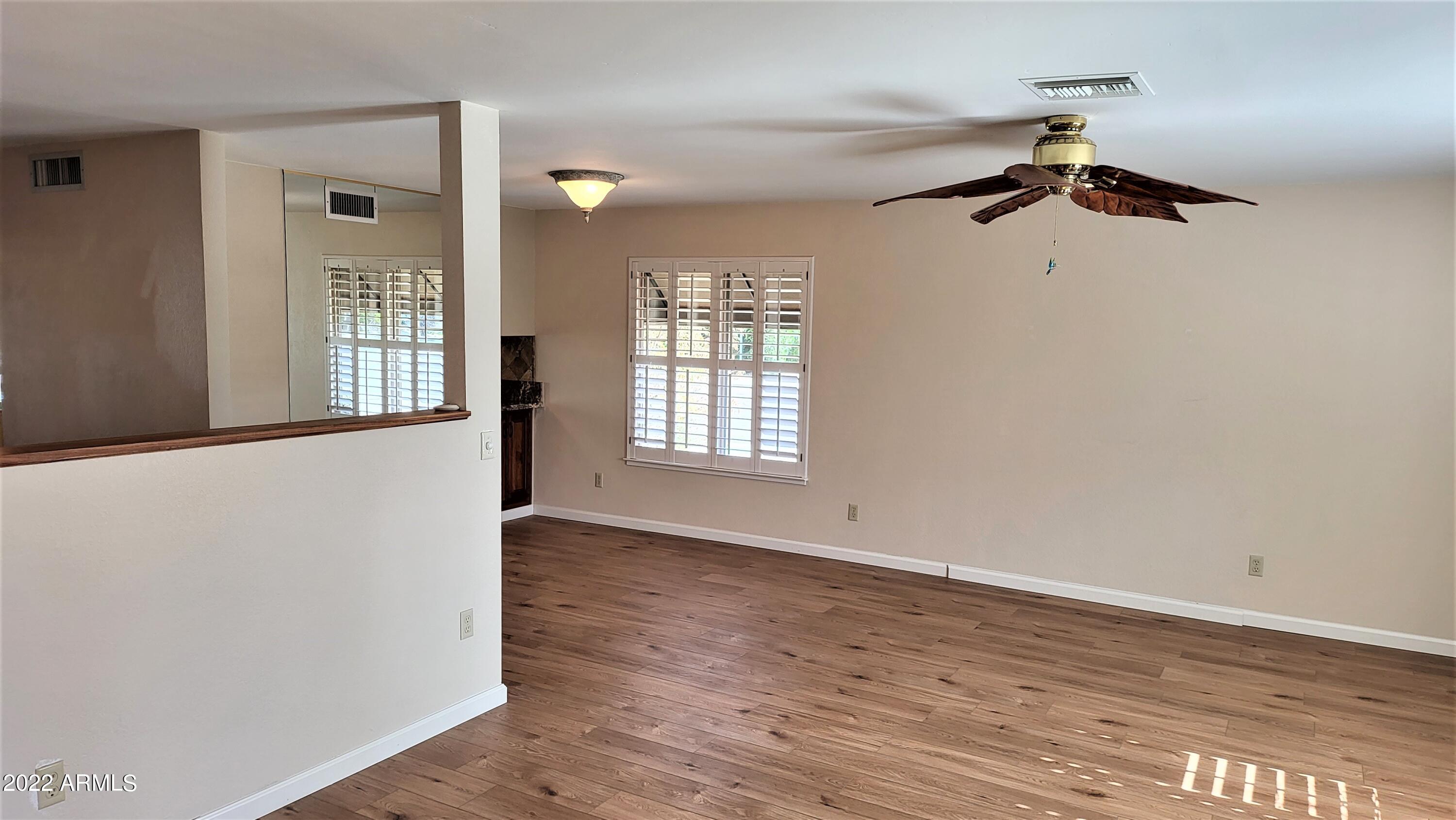 1940 East Hearn Road Phoenix, AZ 85022 - Photo 51 of 51 a view of an empty room with wooden floor and a window