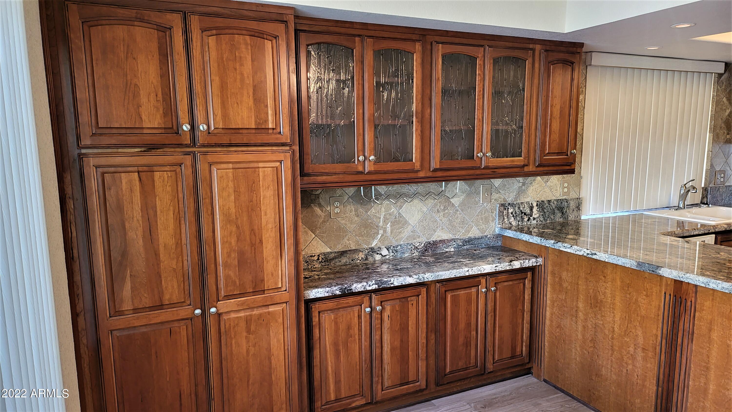 1940 East Hearn Road Phoenix, AZ 85022 - Photo 20 of 51 a kitchen with stainless steel appliances granite countertop wooden cabinets a sink and a dishwasher