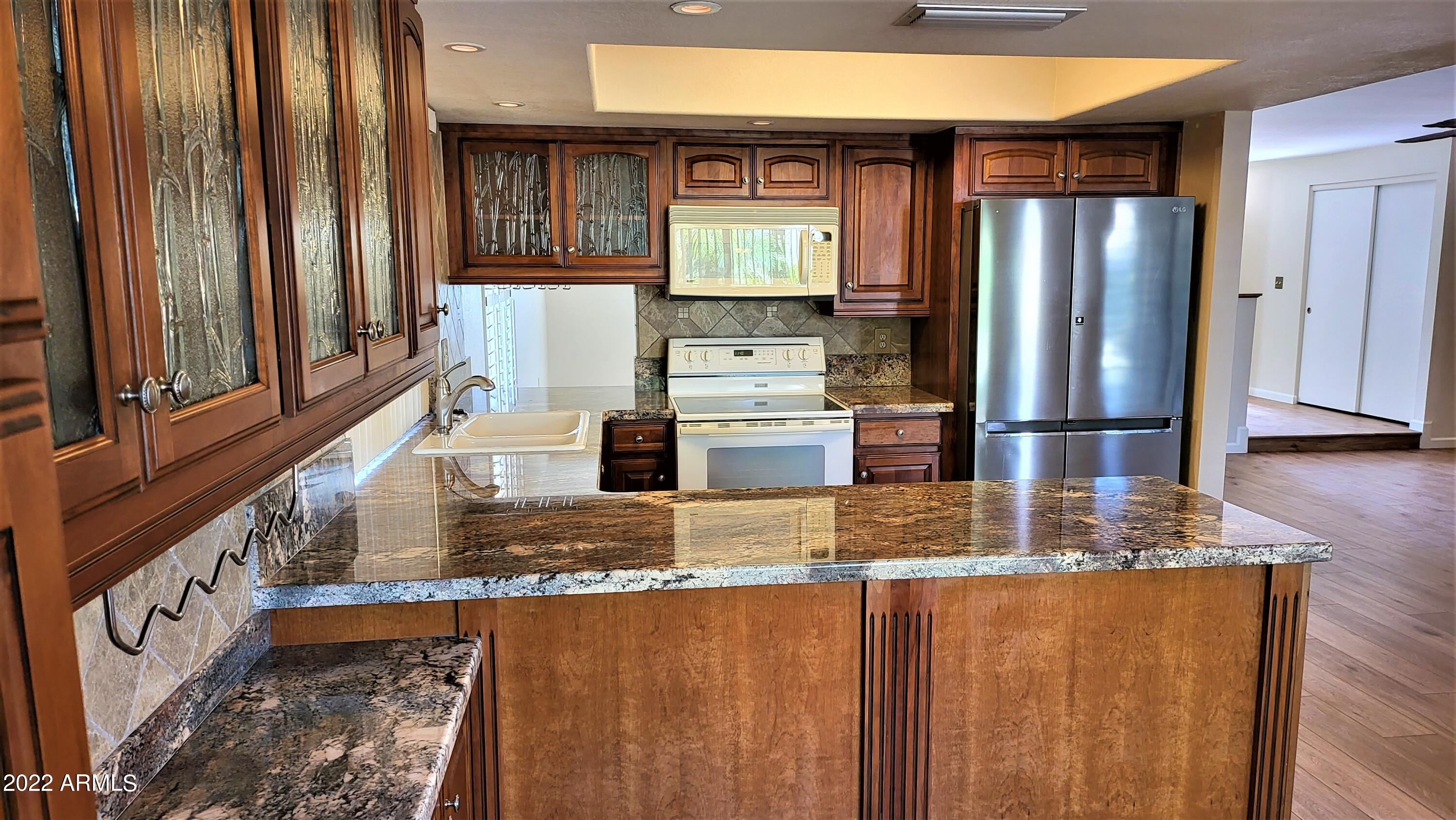 1940 East Hearn Road Phoenix, AZ 85022 - Photo 21 of 51 a kitchen with stainless steel appliances granite countertop a refrigerator and a stove