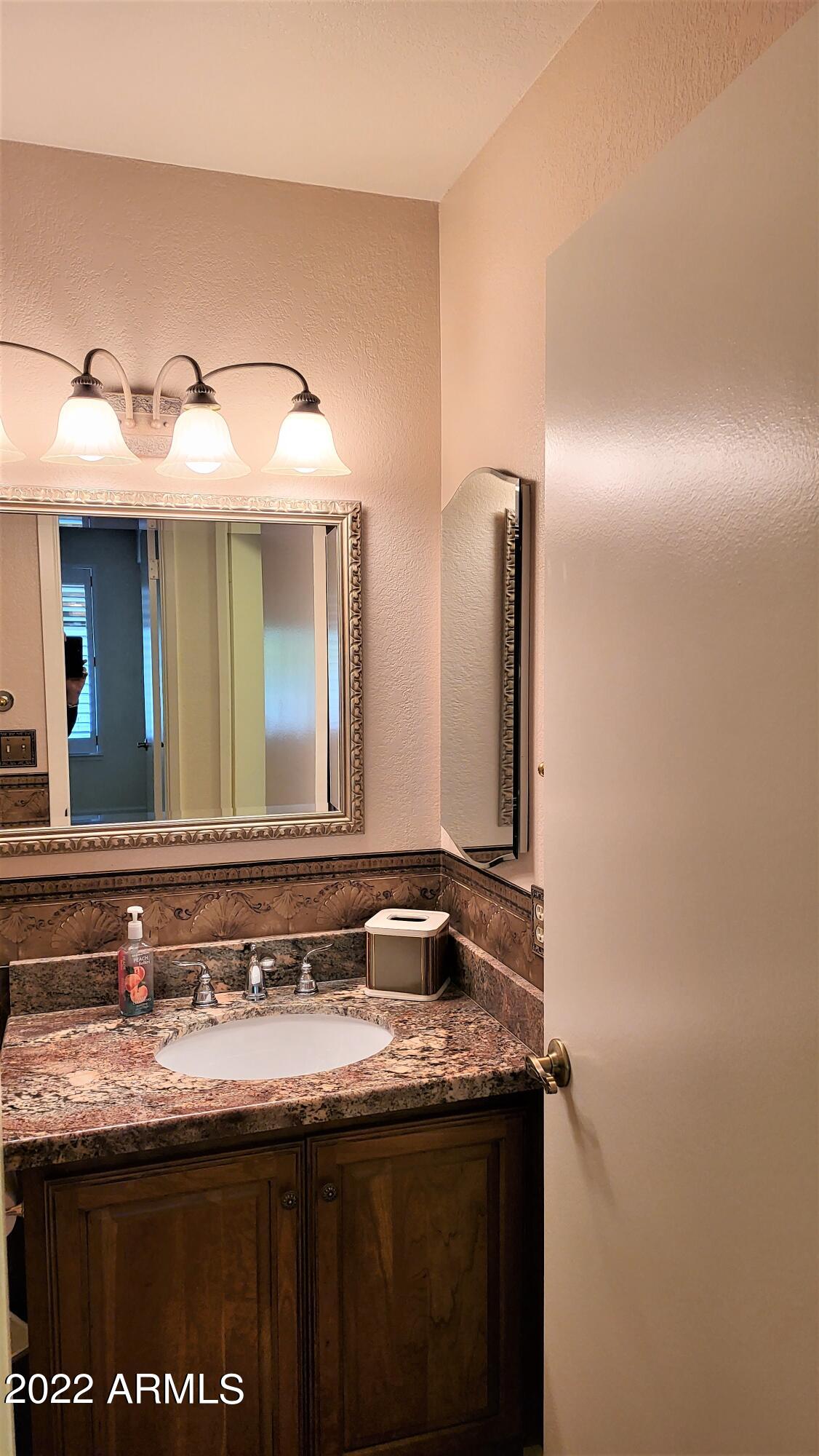 1940 East Hearn Road Phoenix, AZ 85022 - Photo 25 of 51 a bathroom with a granite countertop sink and a mirror