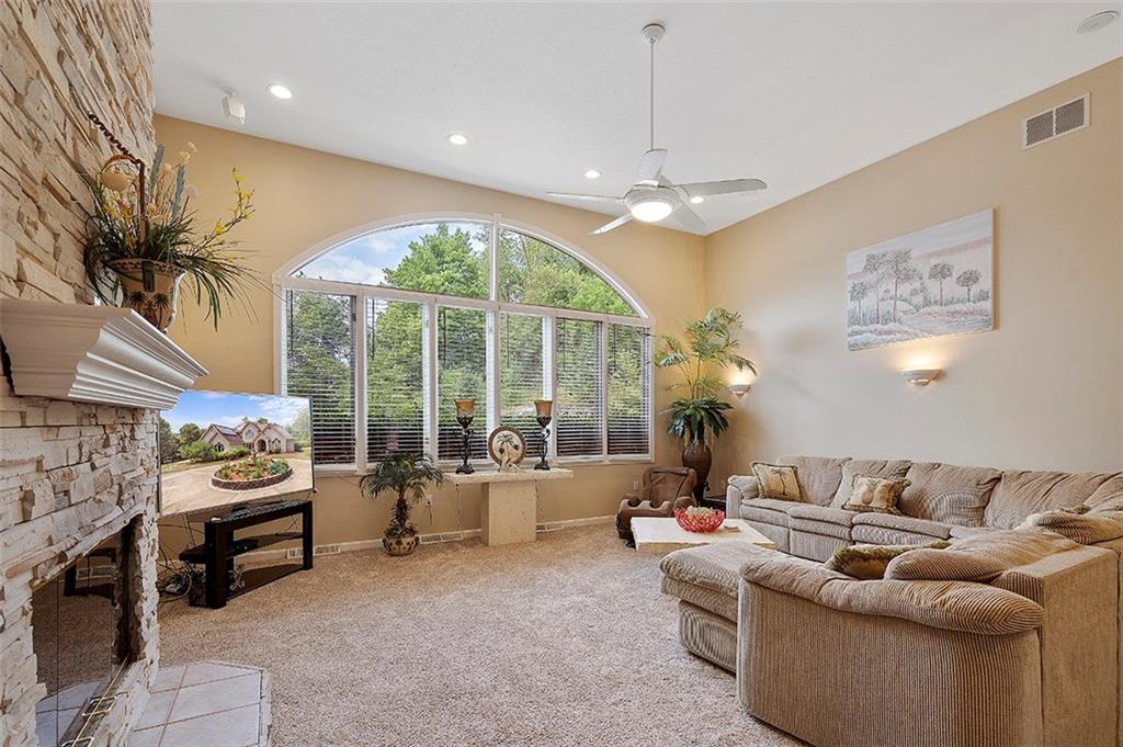 Large living room with two sided fireplace. Lots of natural light