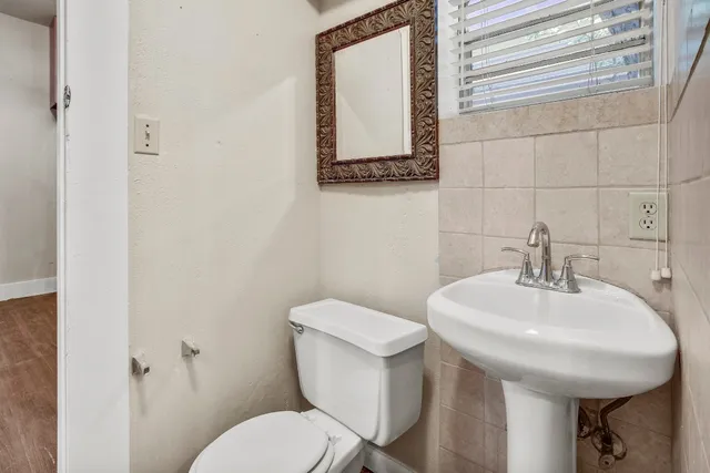 a bathroom with a toilet a sink and mirror