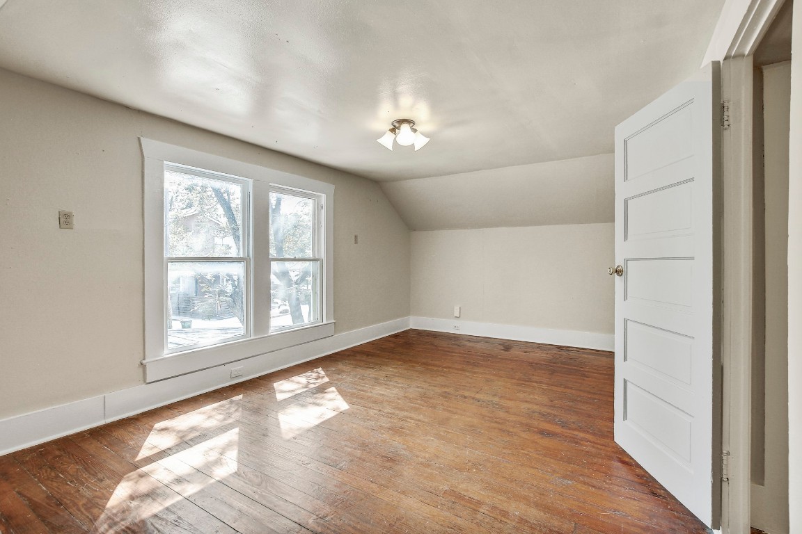704 Franklin Boulevard, Unit A Austin, TX 78751 - Photo 19 of 32 an empty room with wooden floor and windows