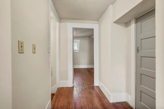 a view of a hallway with wooden floor