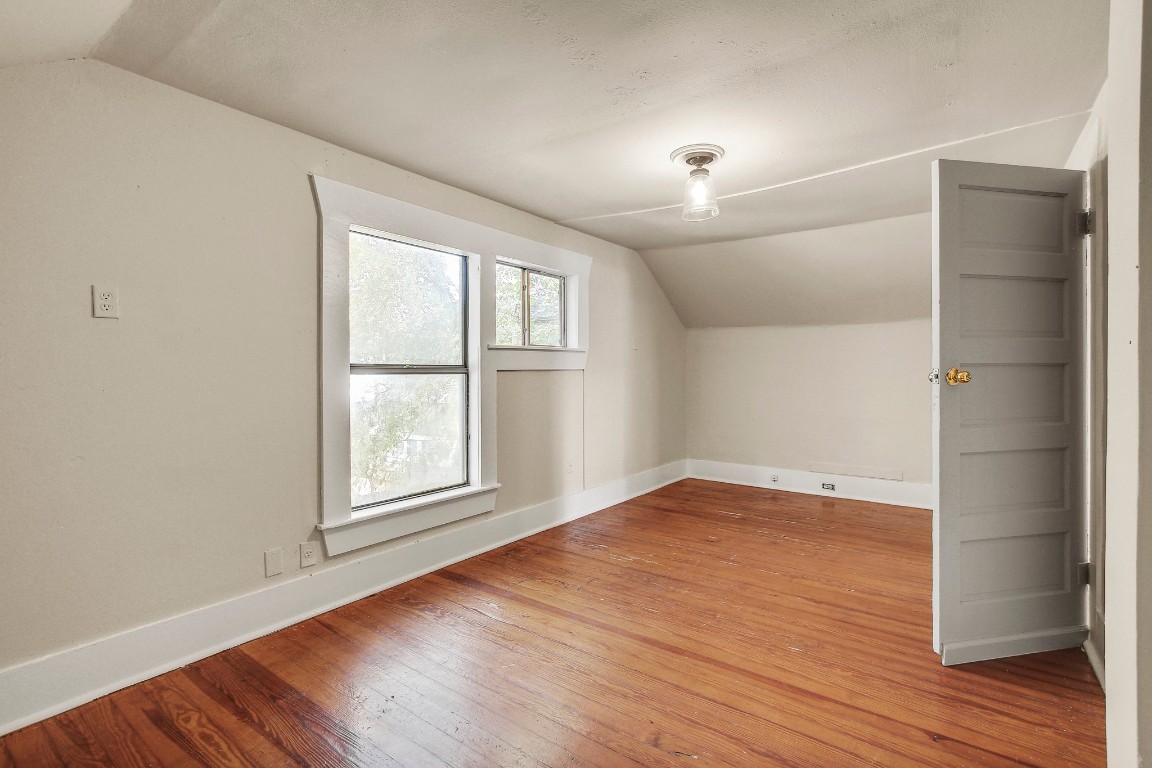 704 Franklin Boulevard, Unit A Austin, TX 78751 - Photo 26 of 32 an empty room with wooden floor and windows