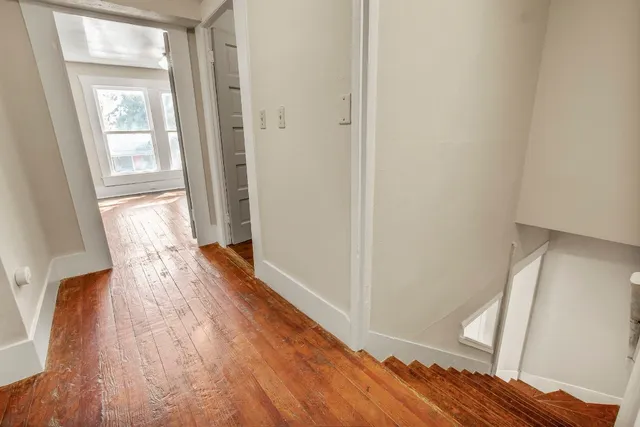 a view of hallway with wooden floor
