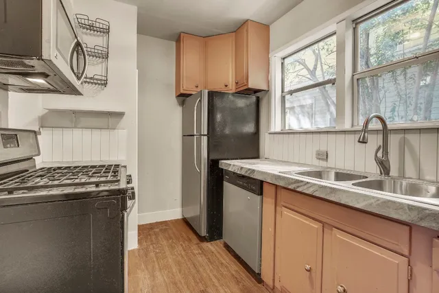 a kitchen with granite countertop a sink stove and refrigerator