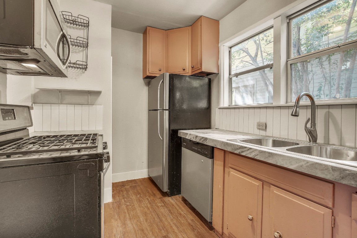 704 Franklin Boulevard, Unit A Austin, TX 78751 - Photo 28 of 32 a kitchen with granite countertop a sink stove and refrigerator