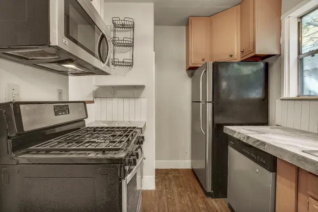 a kitchen with stainless steel appliances granite countertop a stove and a refrigerator