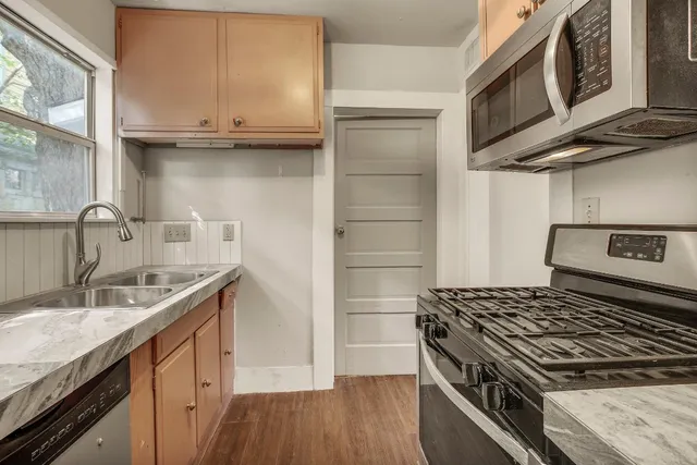 a kitchen with granite countertop a sink stove and cabinets