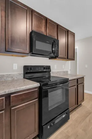 a kitchen with granite countertop cabinets stainless steel appliances and wooden floor