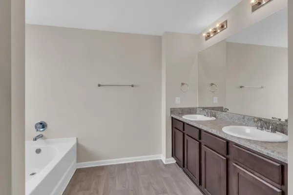 a bathroom with a granite countertop sink and a bathtub