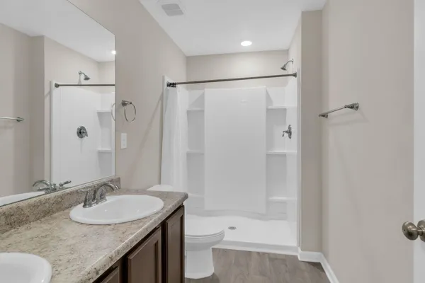 a bathroom with a granite countertop sink toilet and shower