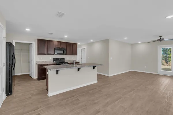 a kitchen with stainless steel appliances granite countertop a refrigerator a sink a stove a microwave and a refrigerator