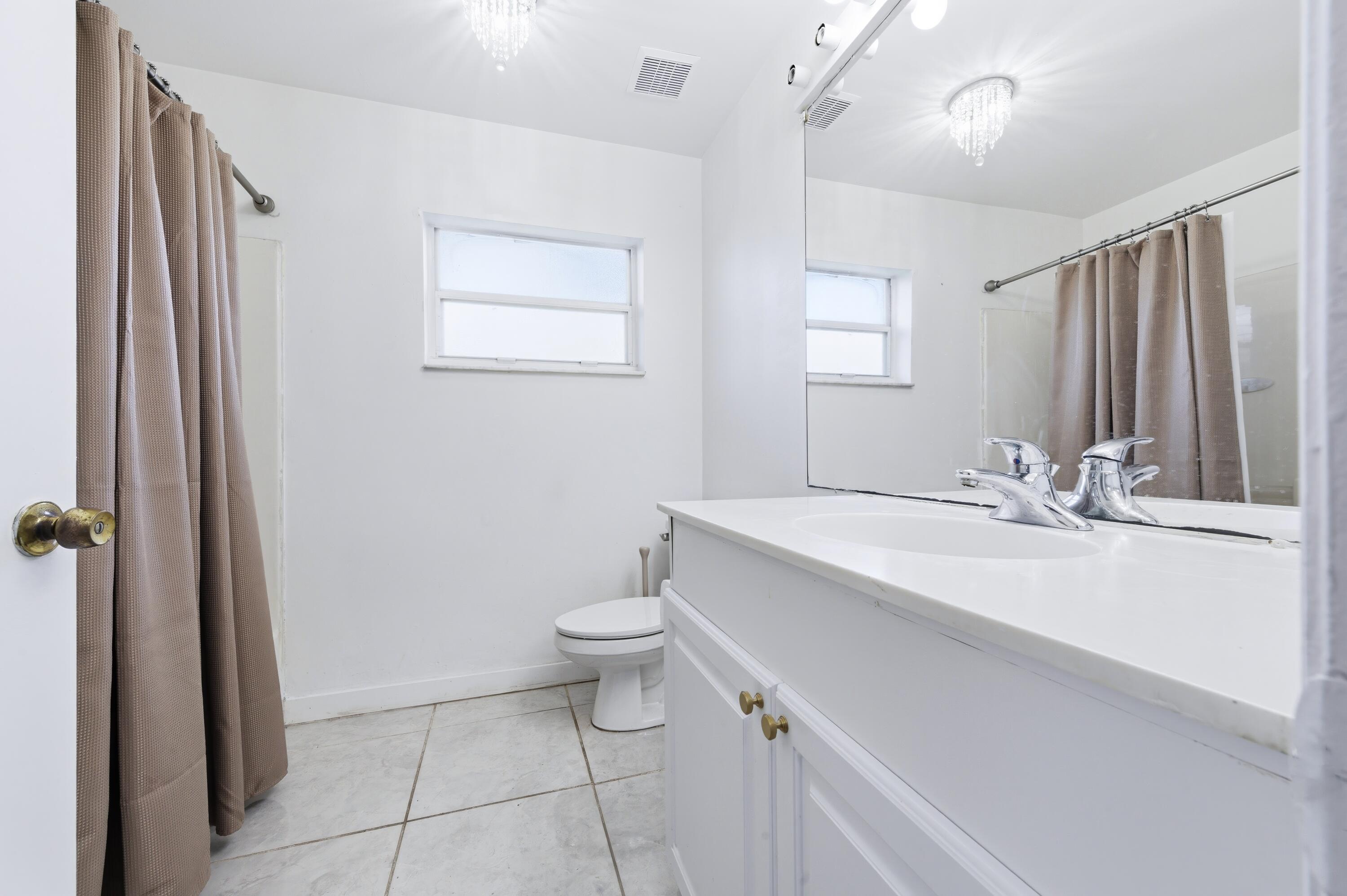 6088 Heather Street Jupiter, FL 33458 - Photo 15 of 18 a bathroom with a sink a toilet and shower