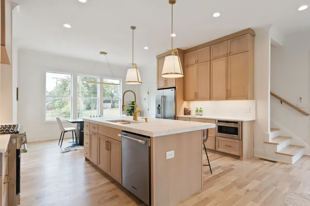 a view of a white house with a small yard and wooden fence