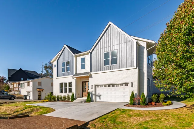 a living room with furniture a large window and wooden floors