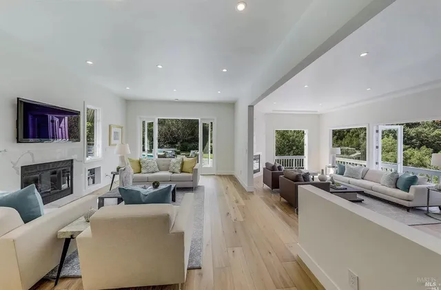 a living room with fireplace furniture and a large window
