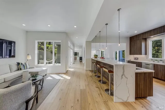 a large kitchen with kitchen island wooden floors and stainless steel appliances