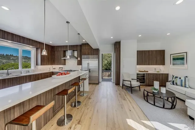 an open kitchen with kitchen island wooden floors and center island