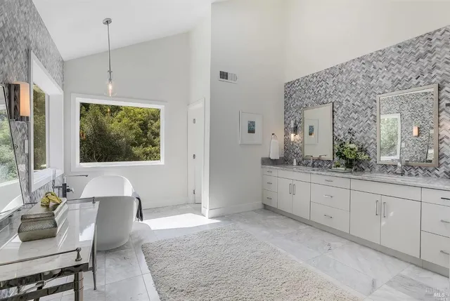 a spacious bathroom with a granite countertop tub sink and mirror