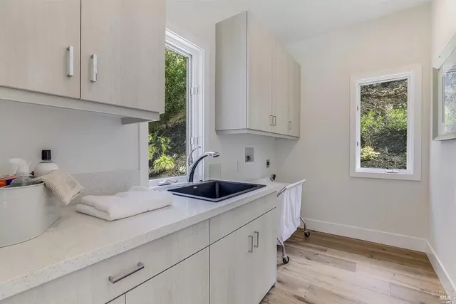 a kitchen with white cabinets and window