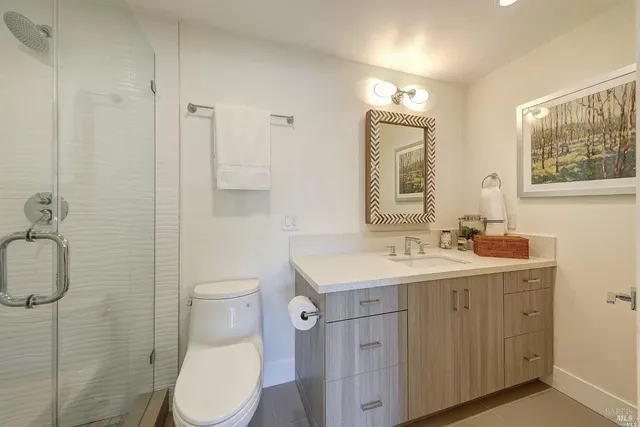 a bathroom with a toilet sink vanity and mirror